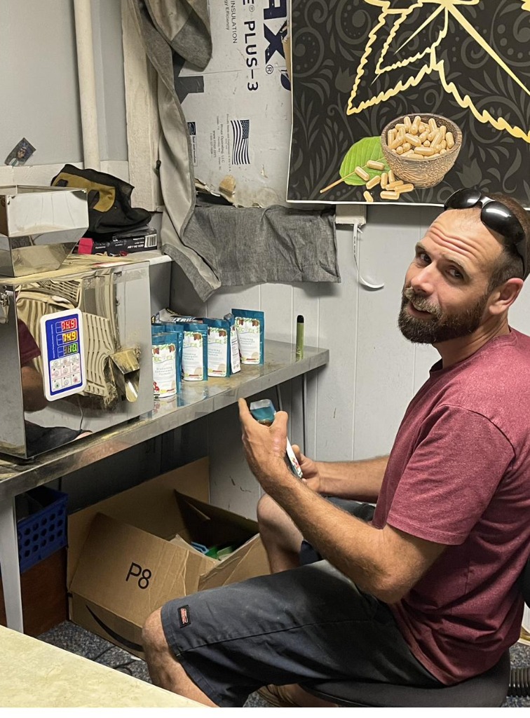 Chris in the EcoFit workshop with product bags on the shelf