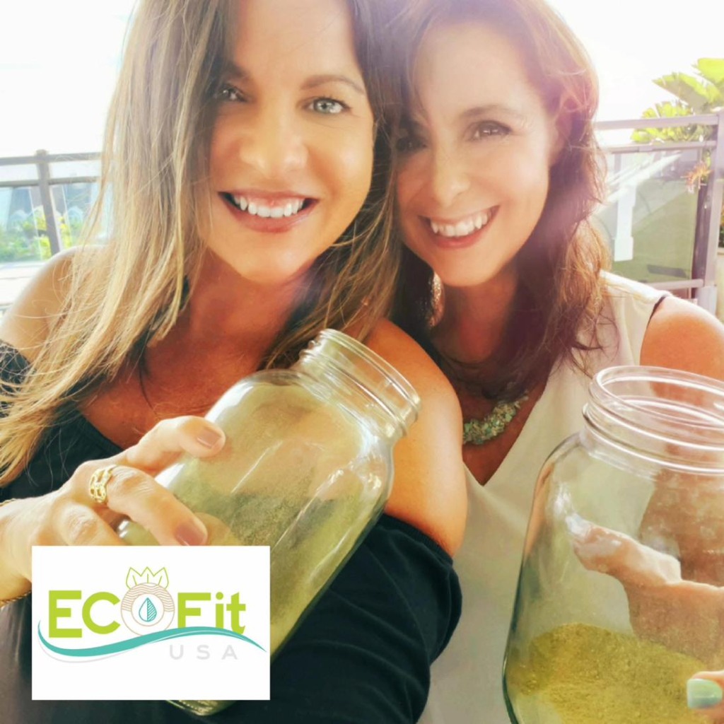 Friends sharing EcoFit — two women holding mason jars of the green drink